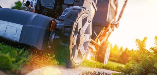 mower cutting grass wheel on edge of pavement 
